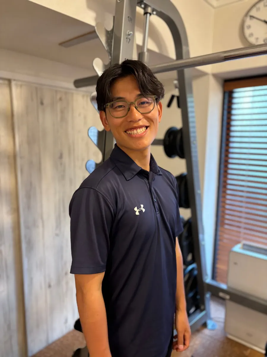 笑顔で正面を向く、理学療法士・アスレティックトレーナーの提坂郁弥